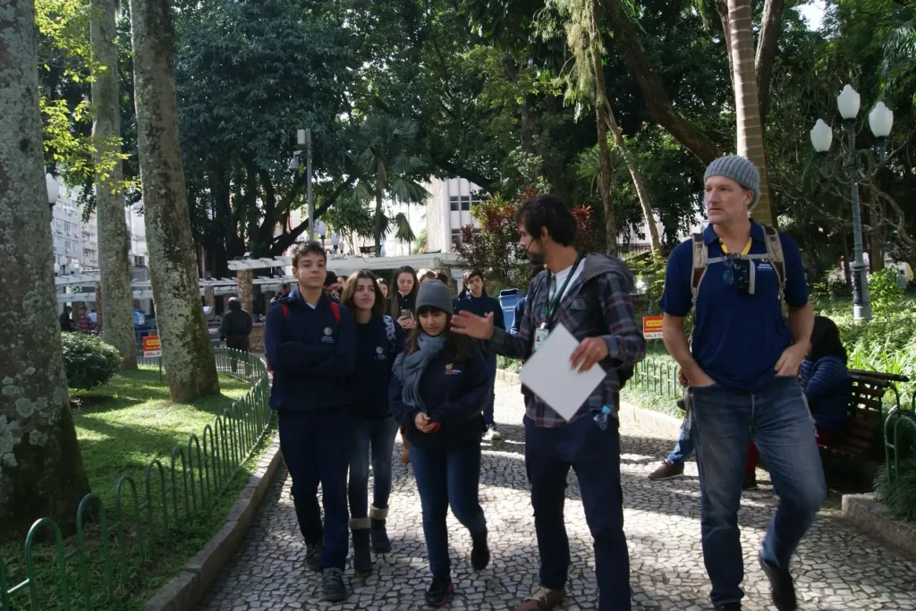 Estudantes caminham com o guia pela praça no Centro de Florianópolis durante o Walking Tour